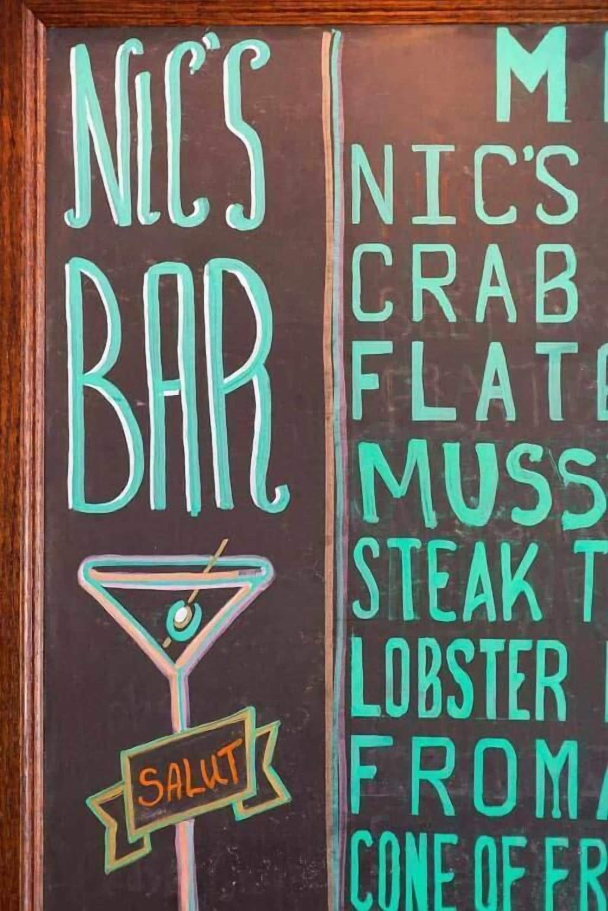 A chalkboard menu for "NICO'S BAR" with items like crab, steak, and lobster.