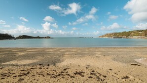 Une plage avec un ciel dégagé et une eau calme.