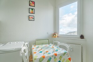 Huoneessa on sänky, pöytä, ikkuna ja patteri.