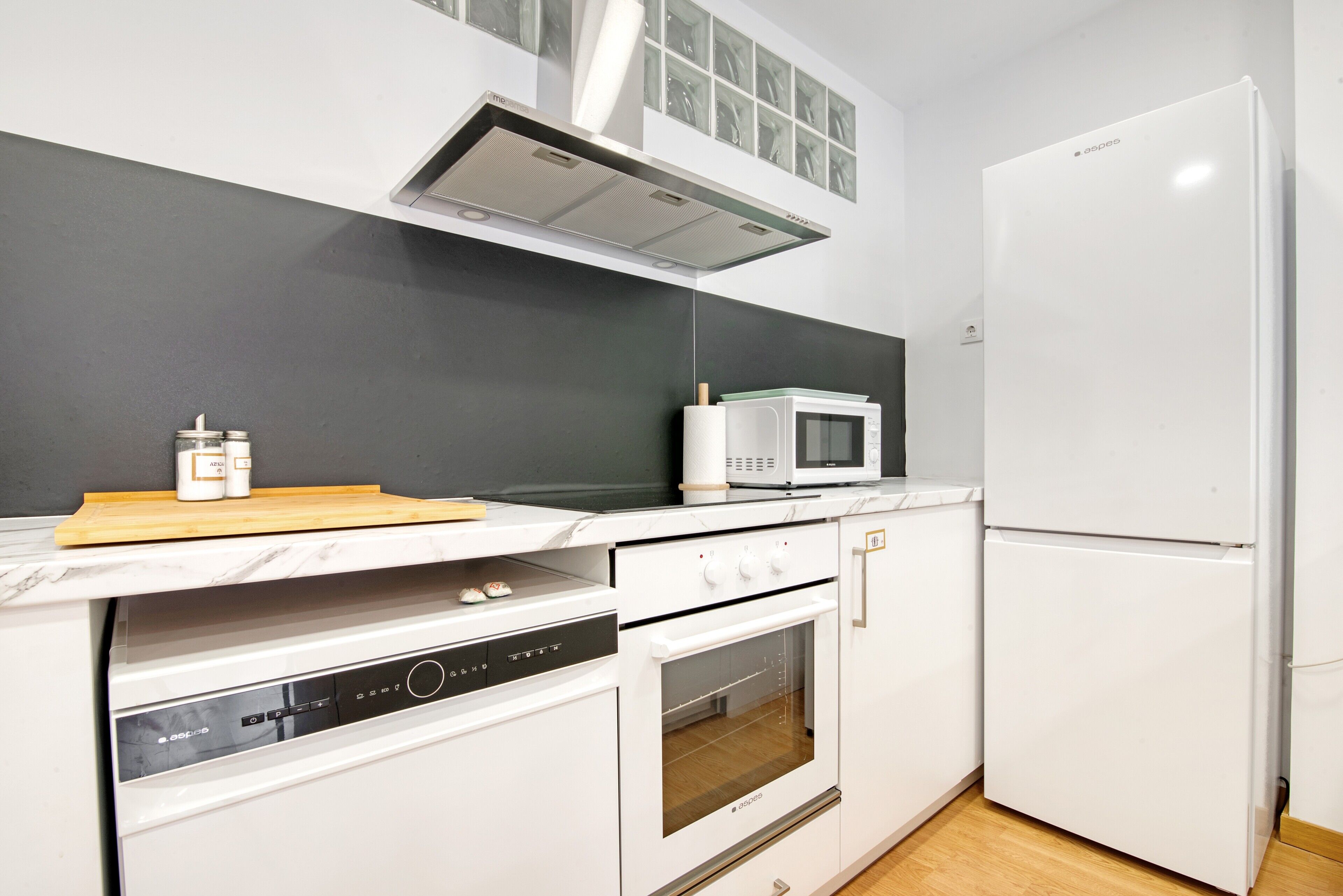A kitchen with a microwave, oven, and refrigerator.