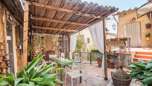 An outdoor patio with a table and chairs, a wicker basket, and potted plants. - Holiday Home 'L'arco Della Fonte' with Private Terrace, Wi-Fi and Air Conditioning (Gaiole in Chianti)