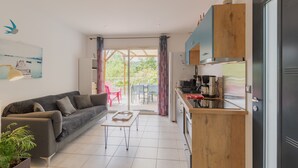 A modern living room with a sofa, coffee table, and a view to an outdoor patio. - Holiday Home 'Le Pequelet' with Shared Pool, Wi-Fi and Air Conditioning (Payzac)