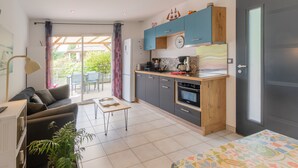 A compact living space with a kitchenette, a dining area, and a sofa. - Holiday Home 'Le Pequelet' with Shared Pool, Wi-Fi and Air Conditioning (Payzac)