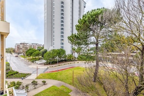 A residential area with a tall building, a curved road, and a pedestrian crossing.
