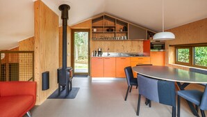 Una cocina moderna con armarios de madera, una estufa negra y un comedor con una mesa redonda y sillas.