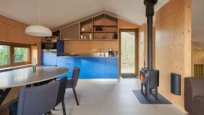 Una cocina moderna con armarios azules, una isla central y una estufa de leña.