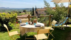 An outdoor dining area with a round table set for four, surrounded by folding chairs. - Villa la Provençale - Roquebrune SUR Argens (ROQUEBRUNE SUR ARGENS)