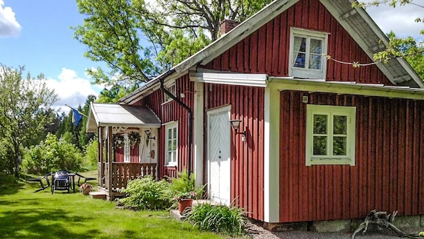 A red wooden house with a porch, a door, and a window. - 3 bedroom gorgeous home in överlida (Överlida)