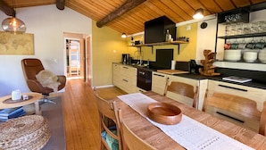 Una cocina acogedora con armarios de madera, una mesa de comedor con sillas y una mesa de centro.