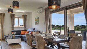 A modern living room with a dining area, large windows, and a view of the outdoors. - Stunning home in Pula (Pula)