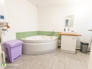 Bathroom features a bathtub, sink, and mirror.