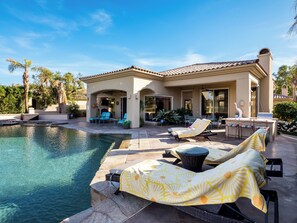 Un espace aménagé au bord de la piscine, avec des chaises longues et un coin salon abrité.