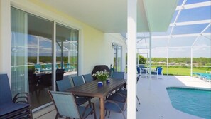 A balcony with a table and chairs, a pool, and a view of the landscape. - Sunset villa on Golf Course - Private Pool (Davenport)