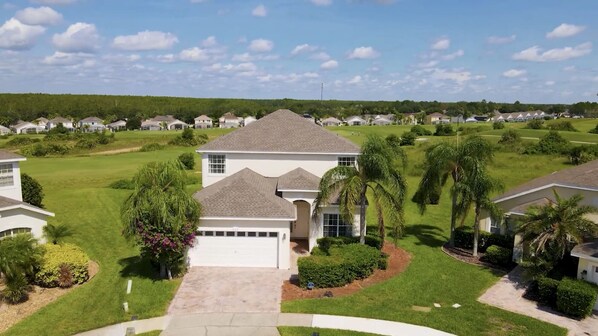 A residential area with houses, well-maintained lawns, and palm trees. - Sunset villa on Golf Course - Private Pool (Davenport)