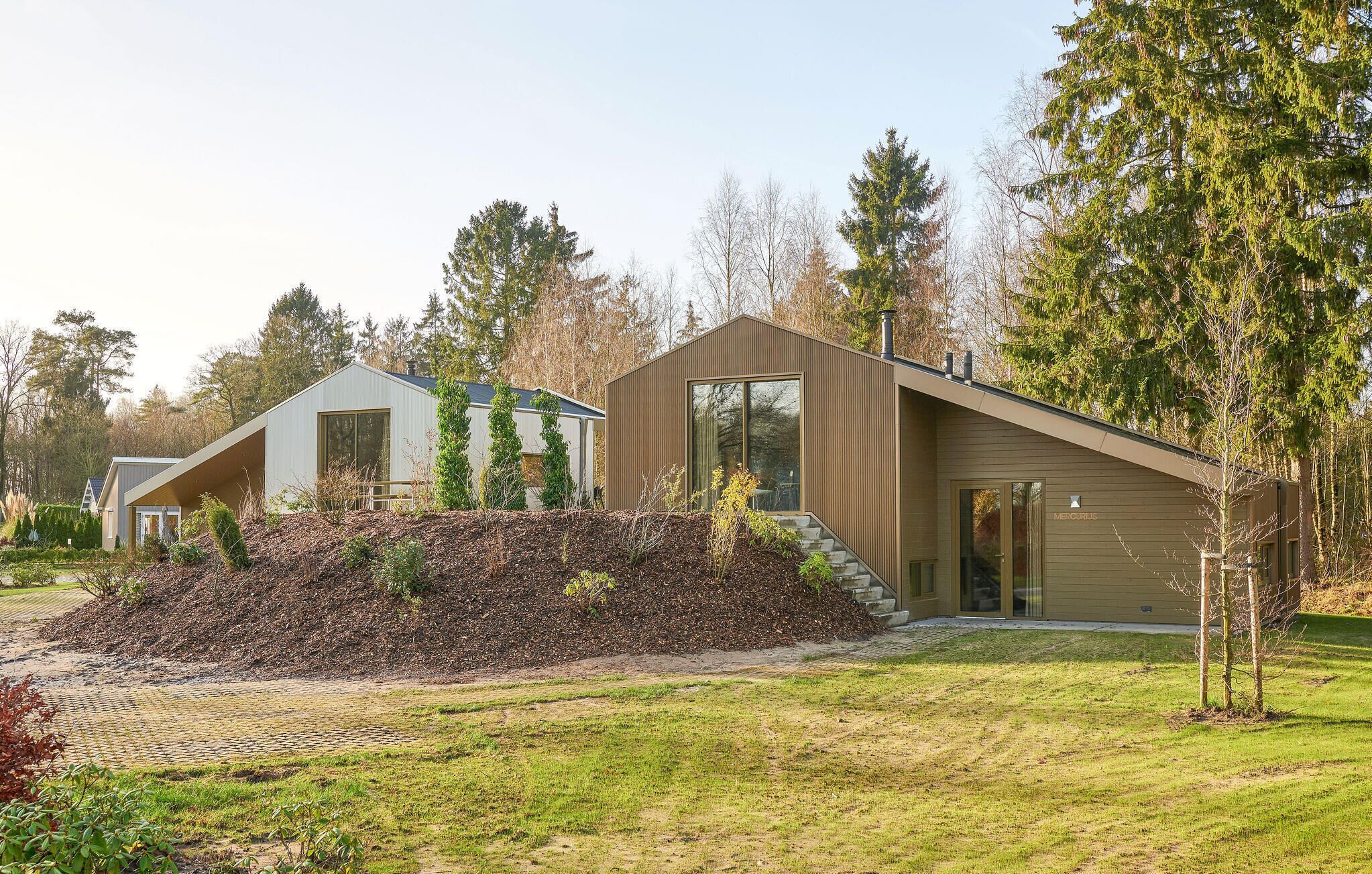 A modern house with a sloped roof, large windows, and a well-maintained garden.