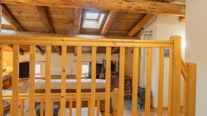 A wooden ceiling with a skylight, a wooden railing, and a tiled floor. - LA Piemontaise - LE Tsozal (AUSSOIS)