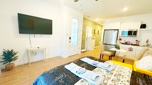 A modern hotel room with a large bed, a desk, a flat-screen TV, a shower, and a kitchenette. - Sequoia Riverway Studio, Visalia Central Nest, 45 minutes to Sequoia Visitor  (Visalia)