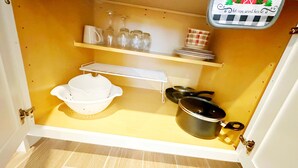 A compact kitchen with a white sink, a stove, and a shelf with glass jars and plates. - Sequoia Riverway Studio, Visalia Central Nest, 45 minutes to Sequoia Visitor  (Visalia)
