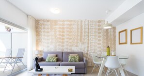 Una sala de estar moderna con sofá, mesa de centro y comedor.