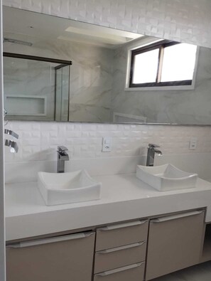 Ein modernes Badezimmer mit zwei Waschbecken, einem großen Spiegel und einem kleinen Fenster.