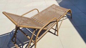 Une terrasse sur le toit, dotée d’un fauteuil de salon en osier, d’une piscine et offrant une vue dégagée sur le paysage environnant.
