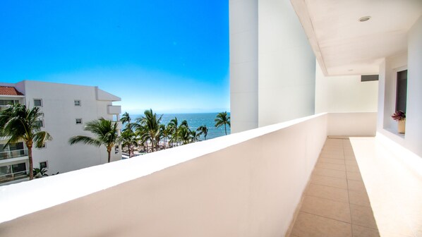 A balcony with a view of the ocean and palm trees. - Villa Magna, Alcatraz, 4BR Oasis with Breathtaking Views (Nuevo Vallarta)
