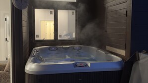 A hot tub with steam rising, a wooden bench, and a door leading to a room. - Modern Luxury 3BR Condo Steps Away from Deer Valley Resort w/ Hot Tub, Fireplace (Park City)