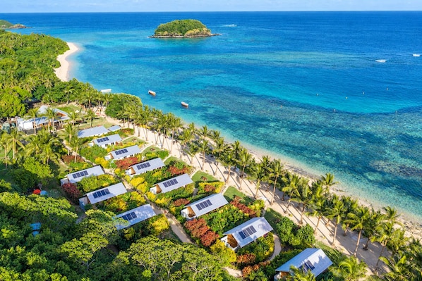 A coastal resort with multiple bungalow-style accommodations, a sandy beach, and a clear view of the ocean. - Mai Sunset Beach Resort (Naviti Island)