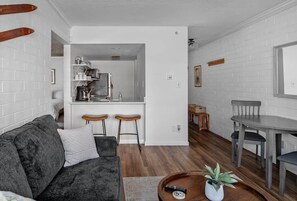 Un espacio habitable compacto con sofá, una mesa de comedor y una zona de cocina.