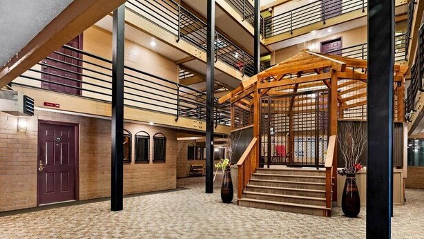 A multi-level atrium with a wooden gazebo, a staircase, and a red door. - Prospector Place - 2(King)Bed 2Bath - Easy to ski! (Park City)