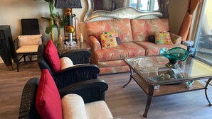 Un salon comprenant un canapé, deux fauteuils, une table basse et une lampe.