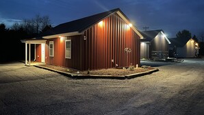 Un bâtiment à deux étages, à la façade rouge et doté d’un porche abrité.