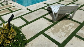 A swimming pool area with lounge chairs and a pergola.