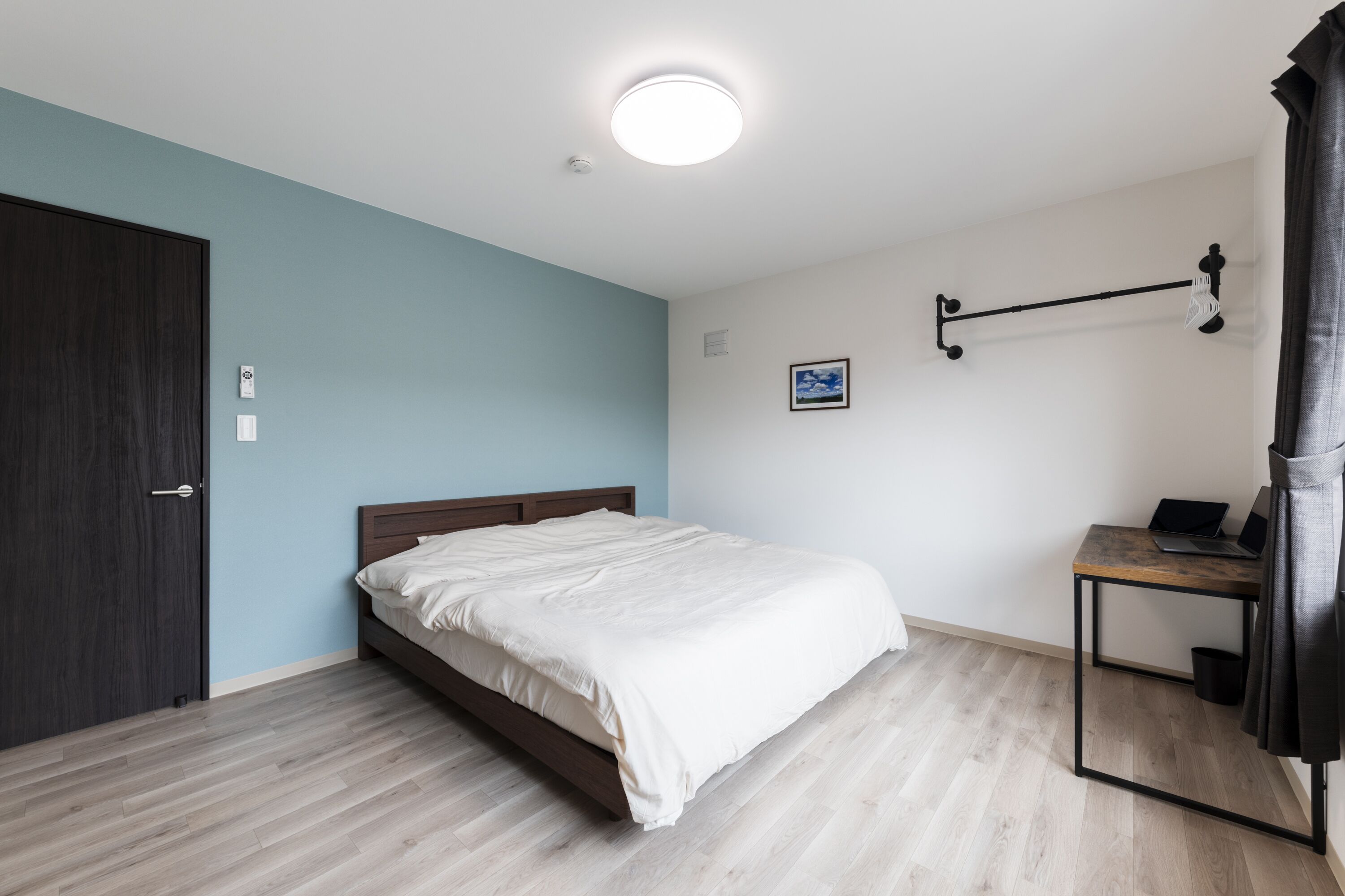 Un dormitorio con una cama, un escritorio y una silla.