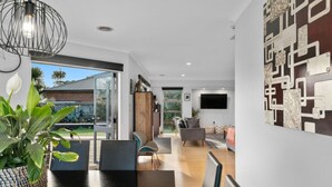 Una sala de estar moderna con comedor, un ventanal y vistas al exterior.