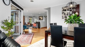 Una sala de estar moderna con comedor, un sofá, una mesa de centro y una planta en maceta.