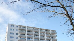 A multi-story building with a uniform facade, balconies, and a clear sky. - Loft - Neu ab 15.01.2024 - Cityloft- Modernes Appartement für 2 Personen in Zentraler Lage (Sylt)