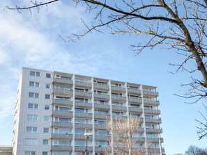 Ein mehrstöckiges Gebäude mit einheitlicher Fassade und Balkonen unter einem klaren Himmel.