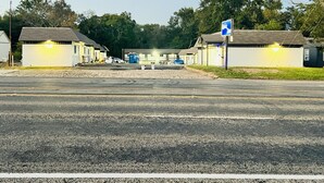 A motel with multiple rooms, a parking lot, and a blue sign indicating a motel. - Rodeway Inn Mineola (Mineola)