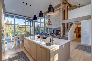 A modern kitchen with a large island, wooden cabinets, and pendant lighting. - Nighthawk 3343 - Private Hot Tub, Mountain Views, Above Whistler Golf Course (Whistler)