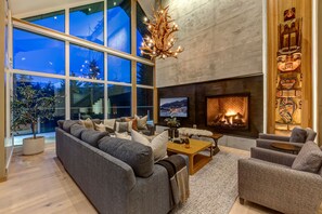 A modern living room with a large sofa, a fireplace, and a television. - Nighthawk 3343 - Private Hot Tub, Mountain Views, Above Whistler Golf Course (Whistler)