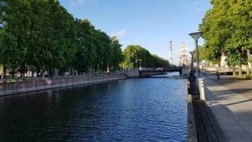 Un río con árboles a un lado y un puente a lo lejos.