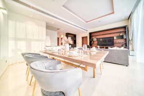 Un comedor moderno con una mesa larga dispuesta para seis personas, rodeada de sillas cómodas.