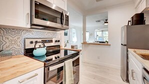 Una cocina moderna con electrodomésticos de acero inoxidable, un salpicadero decorativo y una encimera de madera.