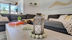 Una sala de estar con una mesa de centro de madera, un farol decorativo y un sofá gris.