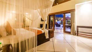 A bedroom with a canopy bed, a view of the outdoor area, and a large window. - Luxury Private Villa in Heart of Seminyak (Seminyak)