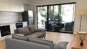 A modern kitchen with white cabinets, a built-in oven, and a black dishwasher. - Quedji Cottage - Beautiful 2 bed private cottage 3 min walk to Dunsborough town. (Dunsborough)