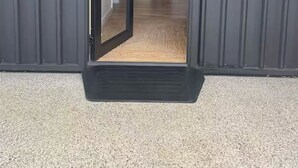 A modern building entrance with a glass door, a wooden floor, and a visible kitchen area in the background. - Quedji Cottage - Beautiful 2 bed private cottage 3 min walk to Dunsborough town. (Dunsborough)