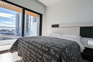 A modern bedroom with a large bed, a view of the city, and a minimalist design. - SUNSET WAVES lovely apartment (Benidorm)