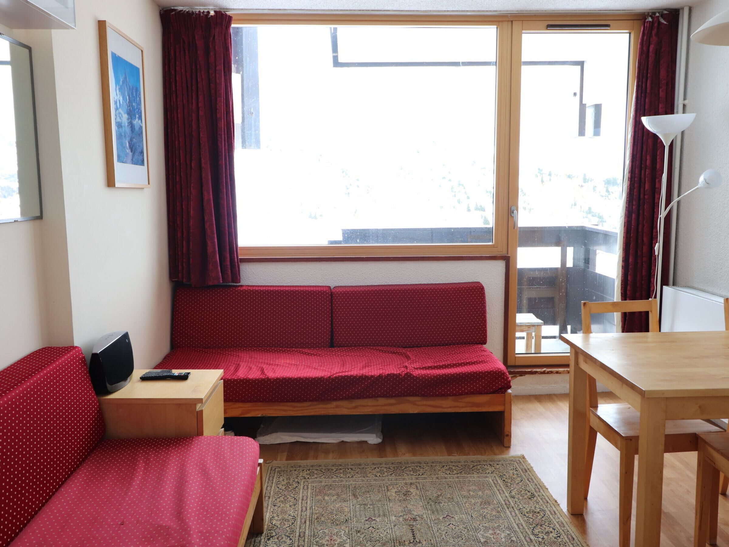 A compact room with a bed, a small desk, a chair, and a table.